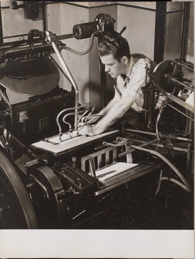 A printer at work on an old printing press